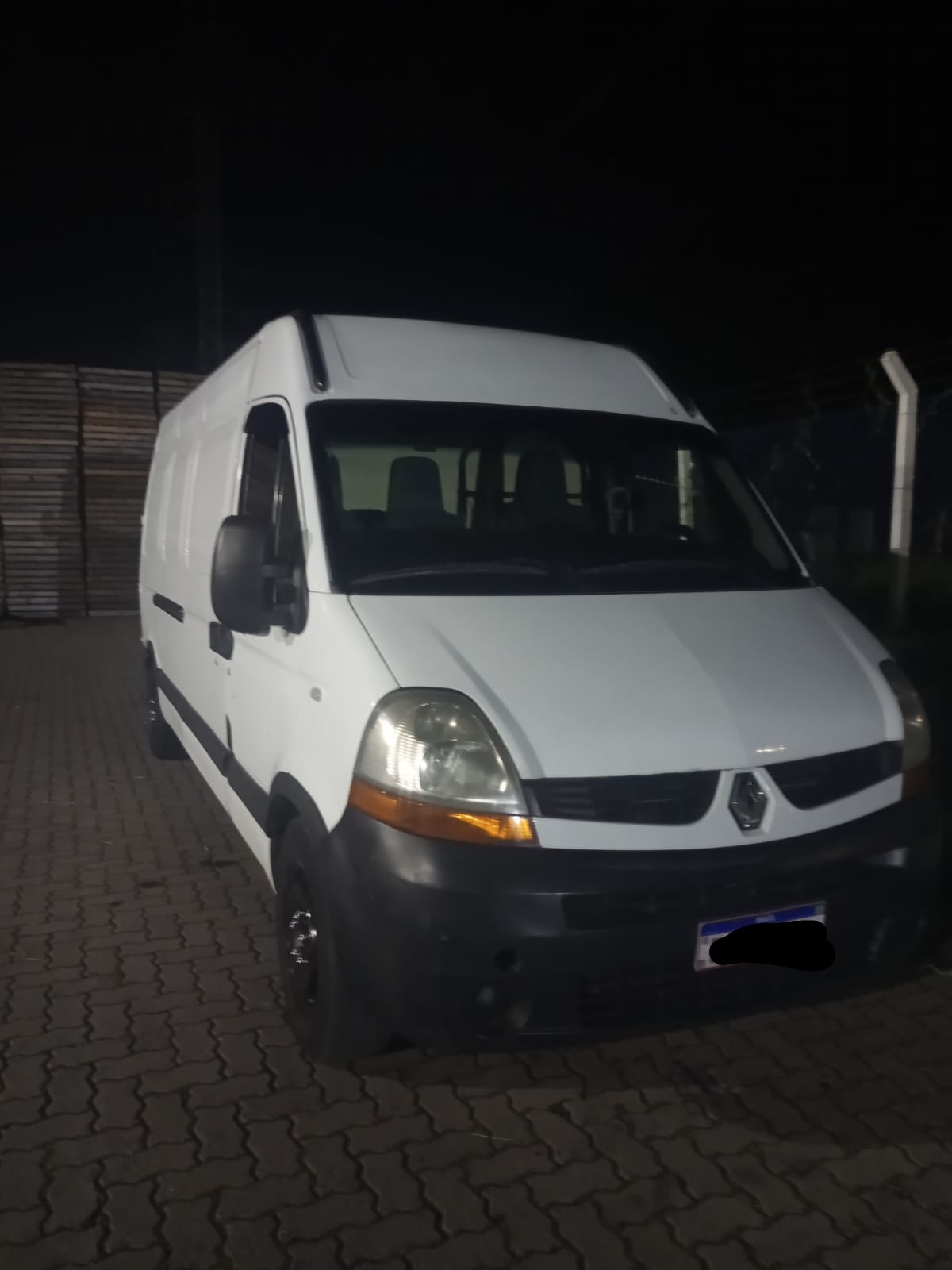 Van Renault Master branca em pátio à noite